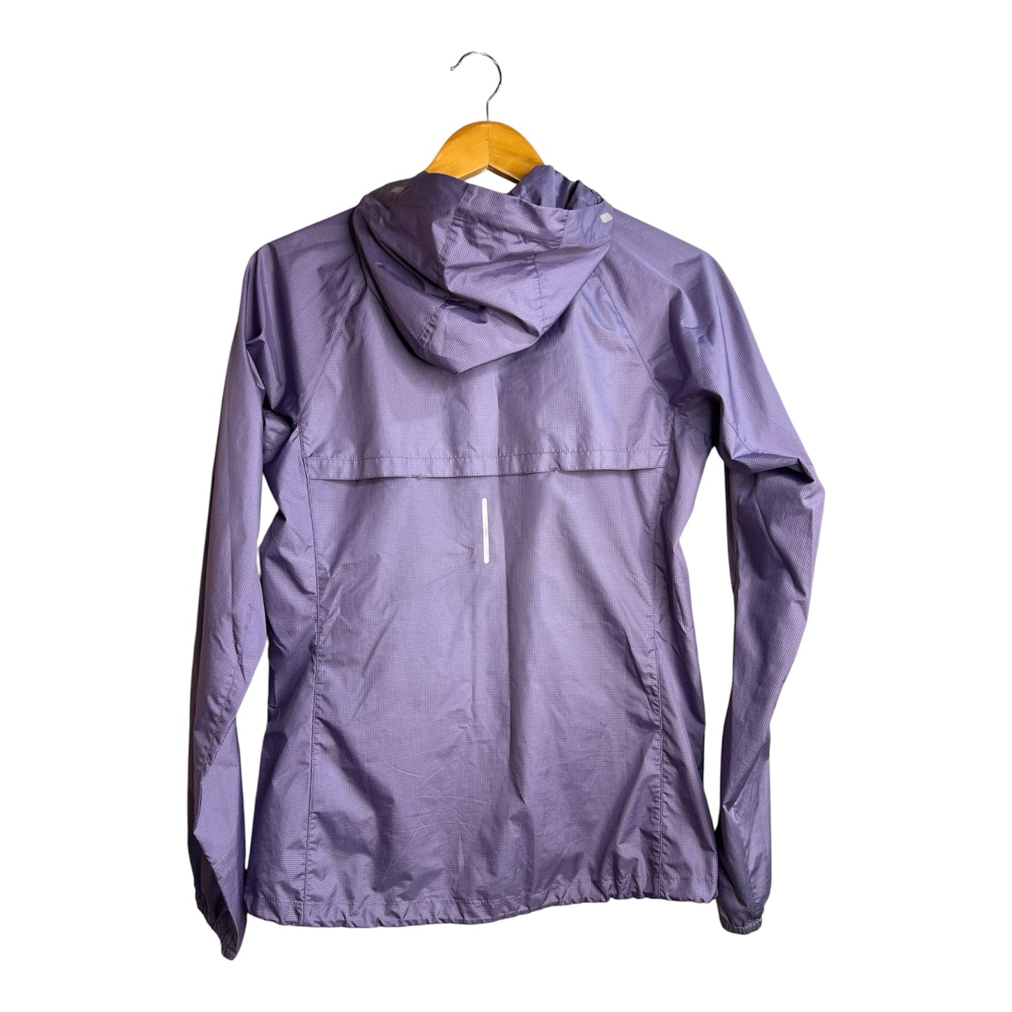 Chaqueta cortavientos morada La Pichilemina con capucha, tejido técnico texturizado y detalle reflectante en la espalda.