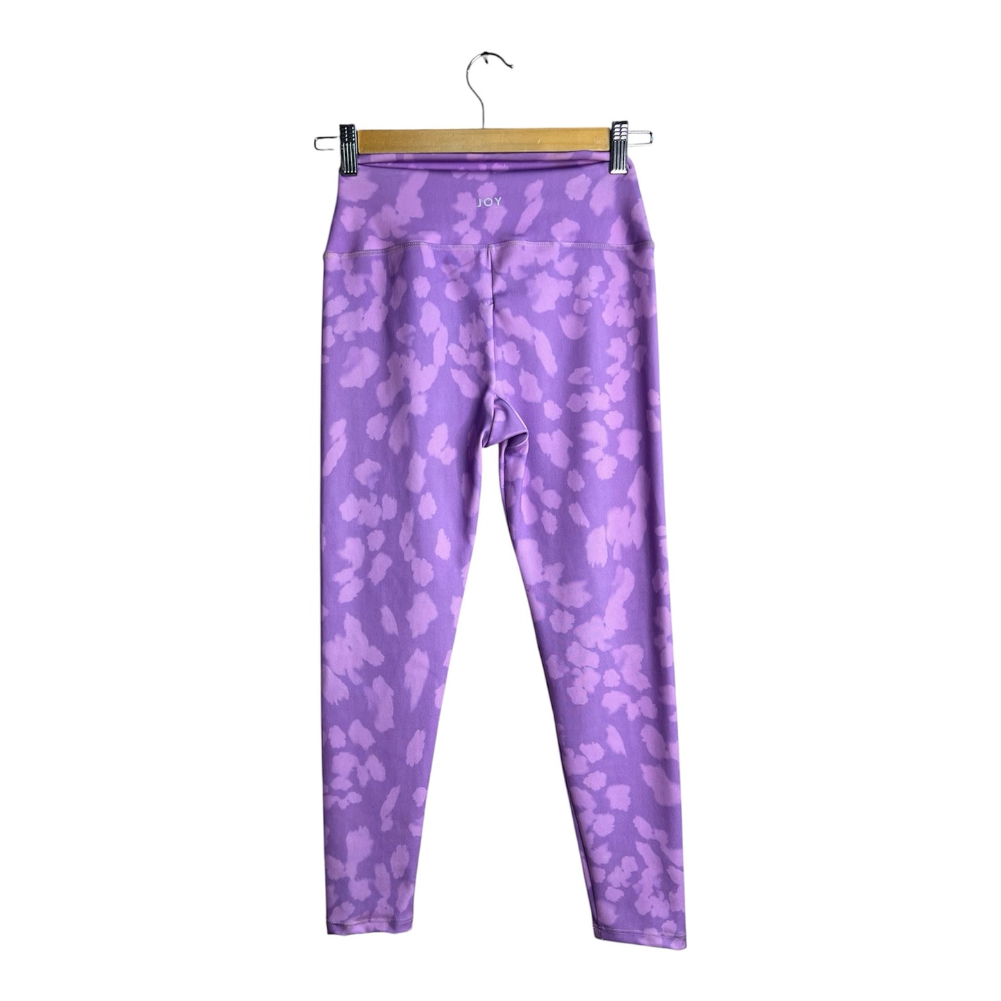 Calzas deportivas La Pichilemina de tiro alto con estampado animal print en tonos violeta y lila sobre fondo blanco.