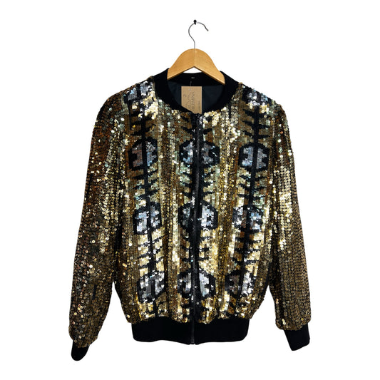 Chaqueta bomber La Pichilemina con lentejuelas doradas, plateadas y negras en patrón geométrico y rib negro.