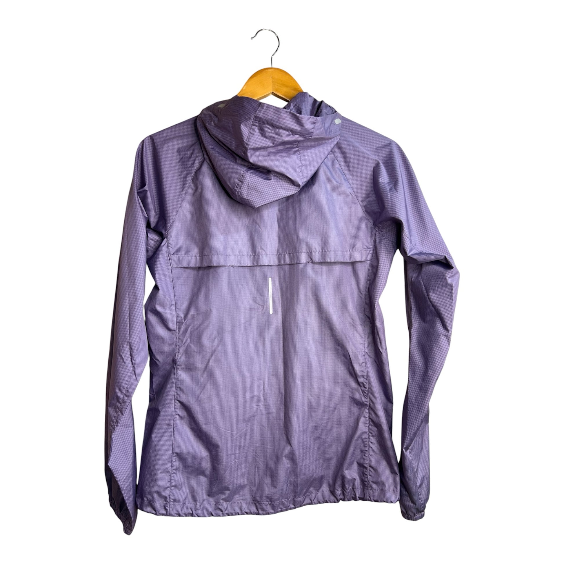 Chaqueta cortavientos morada La Pichilemina con capucha, tejido técnico texturizado y detalle reflectante en la espalda.